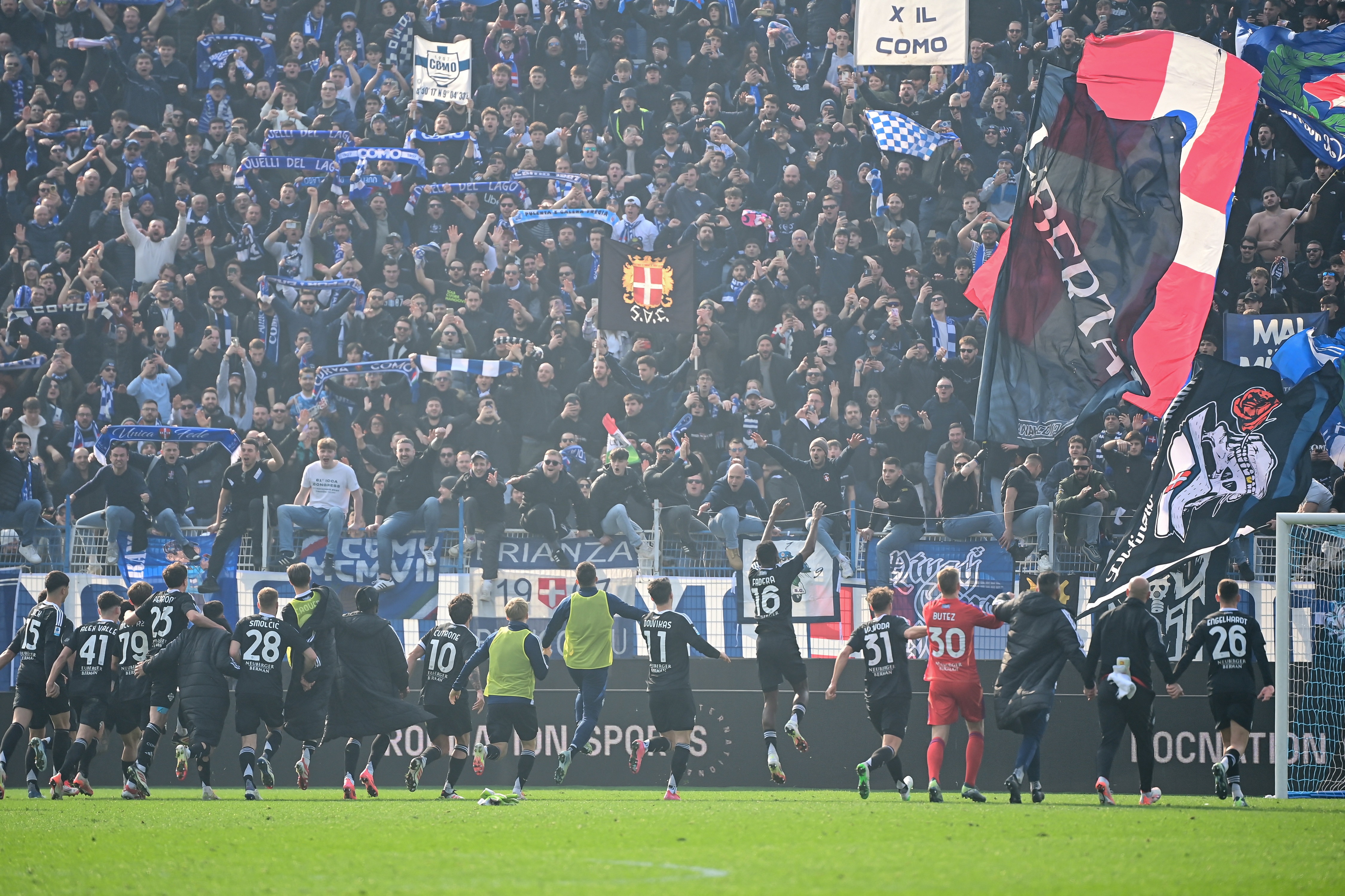 Como players celebrate their 2-1 win over Napoli in February 2025 in front of a raucous crowd of celebrating fans