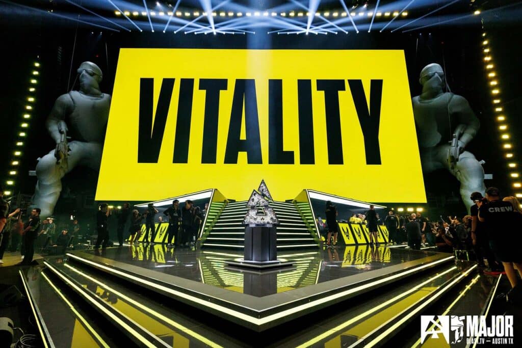 Image of Team Vitality name projected onto large screen above BLAST Austin Major stage. The Major trophy stands on a platform in the centre of the stage