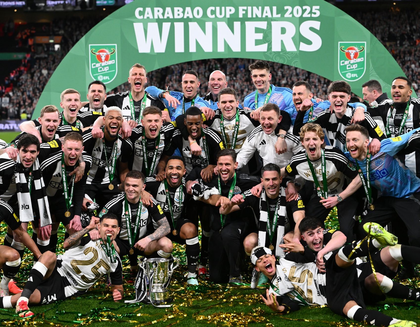 A jubilant team celebrating their victory at the Carabao Cup Final 2025, posing with the trophy and wearing medals.