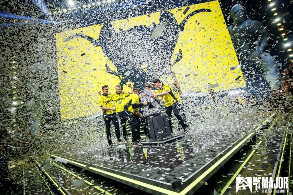 Image of Team Vitality CS2 team lifting BLAST Austin Major trophy. Confetti is surrounding the team celebrating on stage