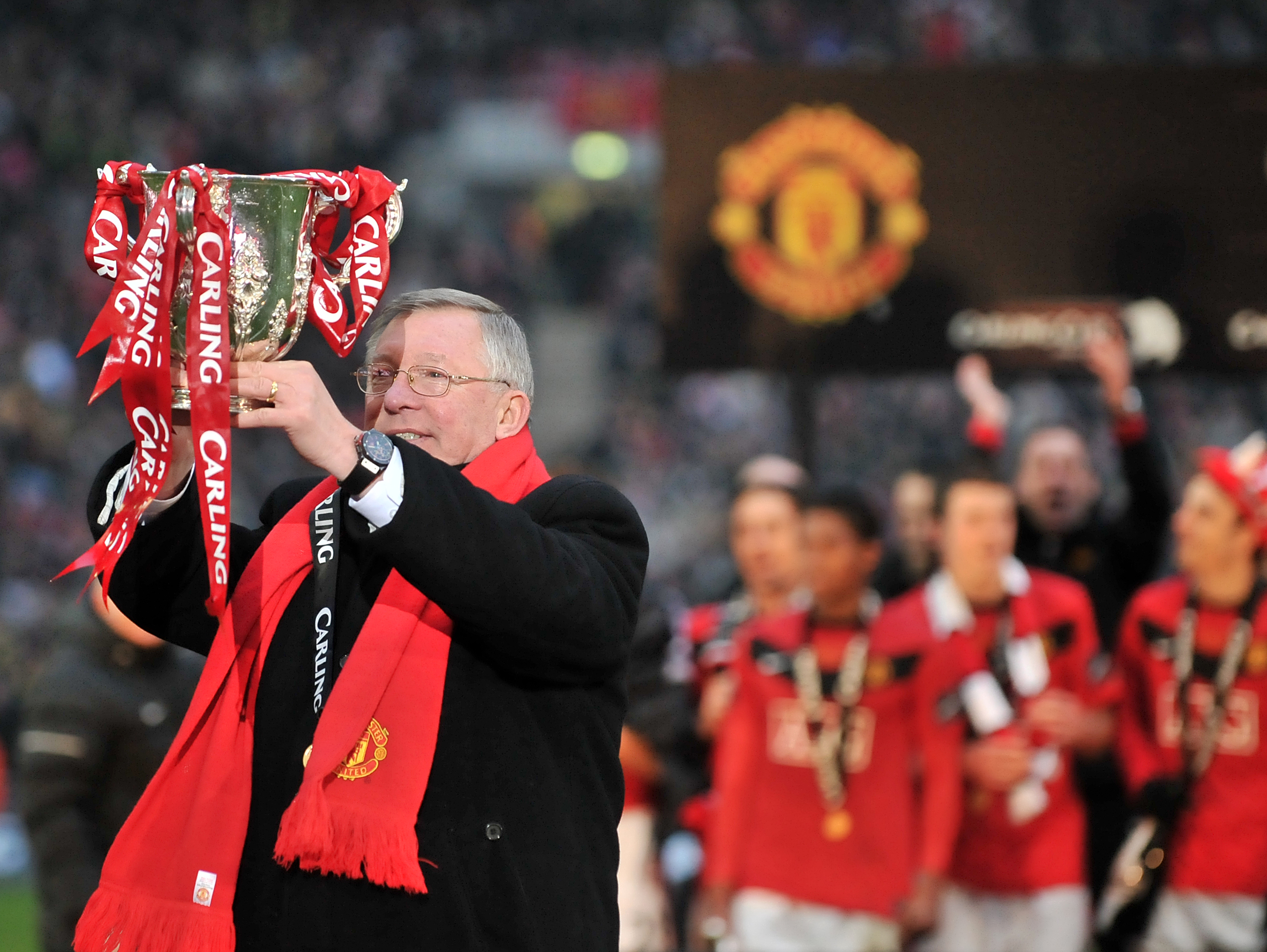 Alex Ferguson celebrates with the League Cup after Manchester United's win over Aston Villa in the final in February 2010.