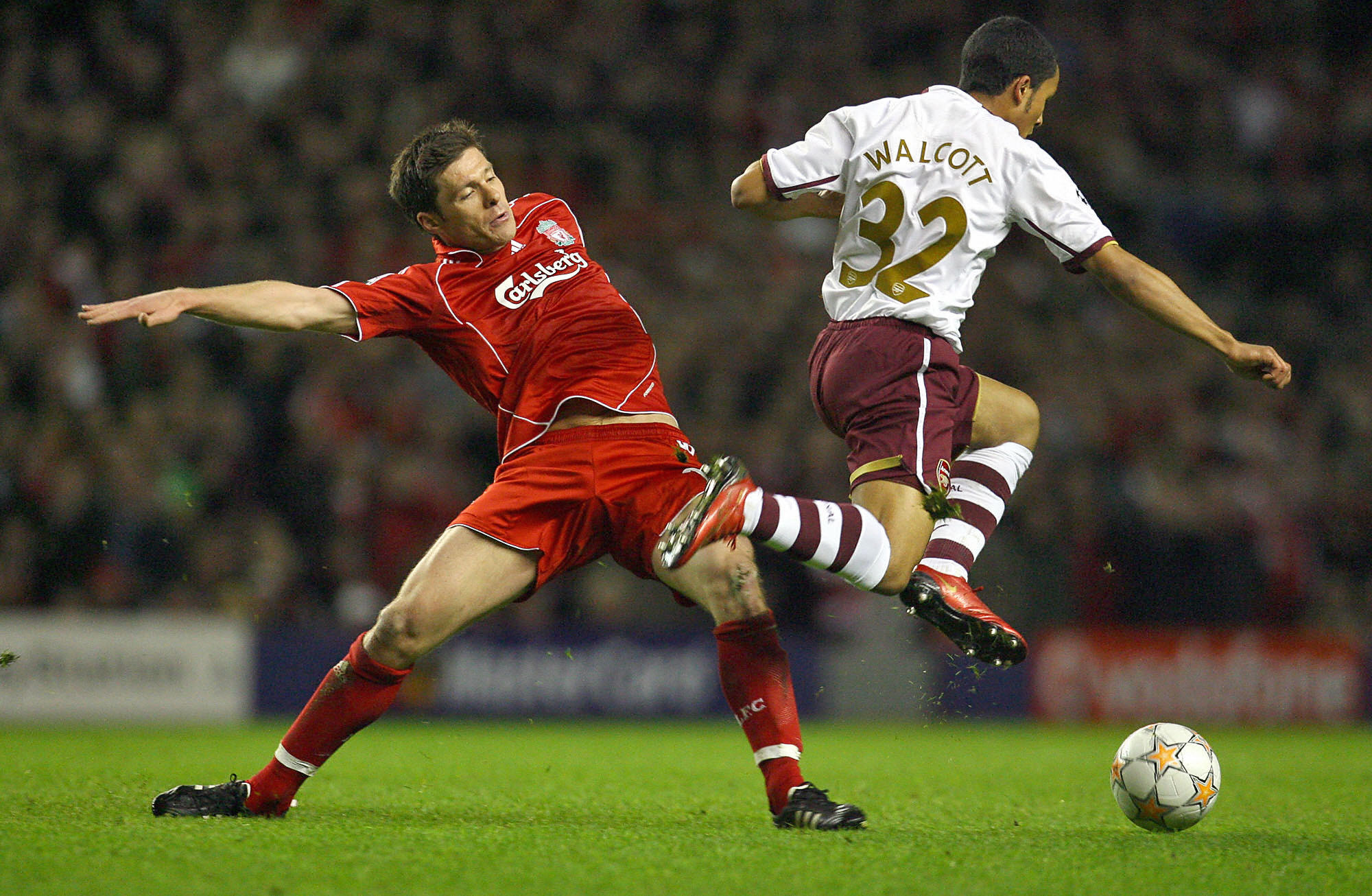Theo Walcott skips past Xabi Alonso