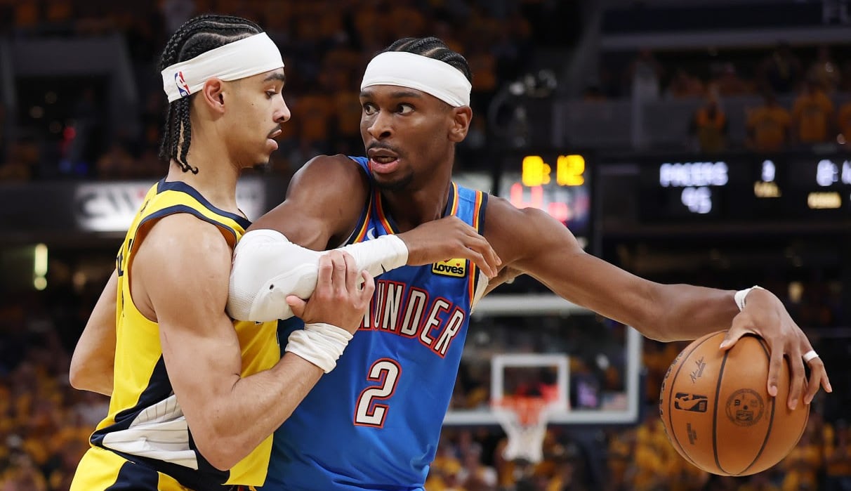 A men's basketball player is guarded during a game.