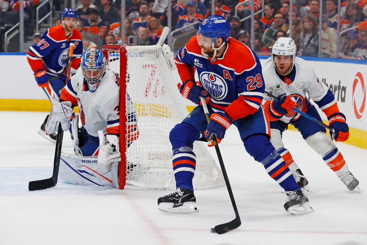 A player for the Edmonton Oilers glides on the ice, controlling the puck.