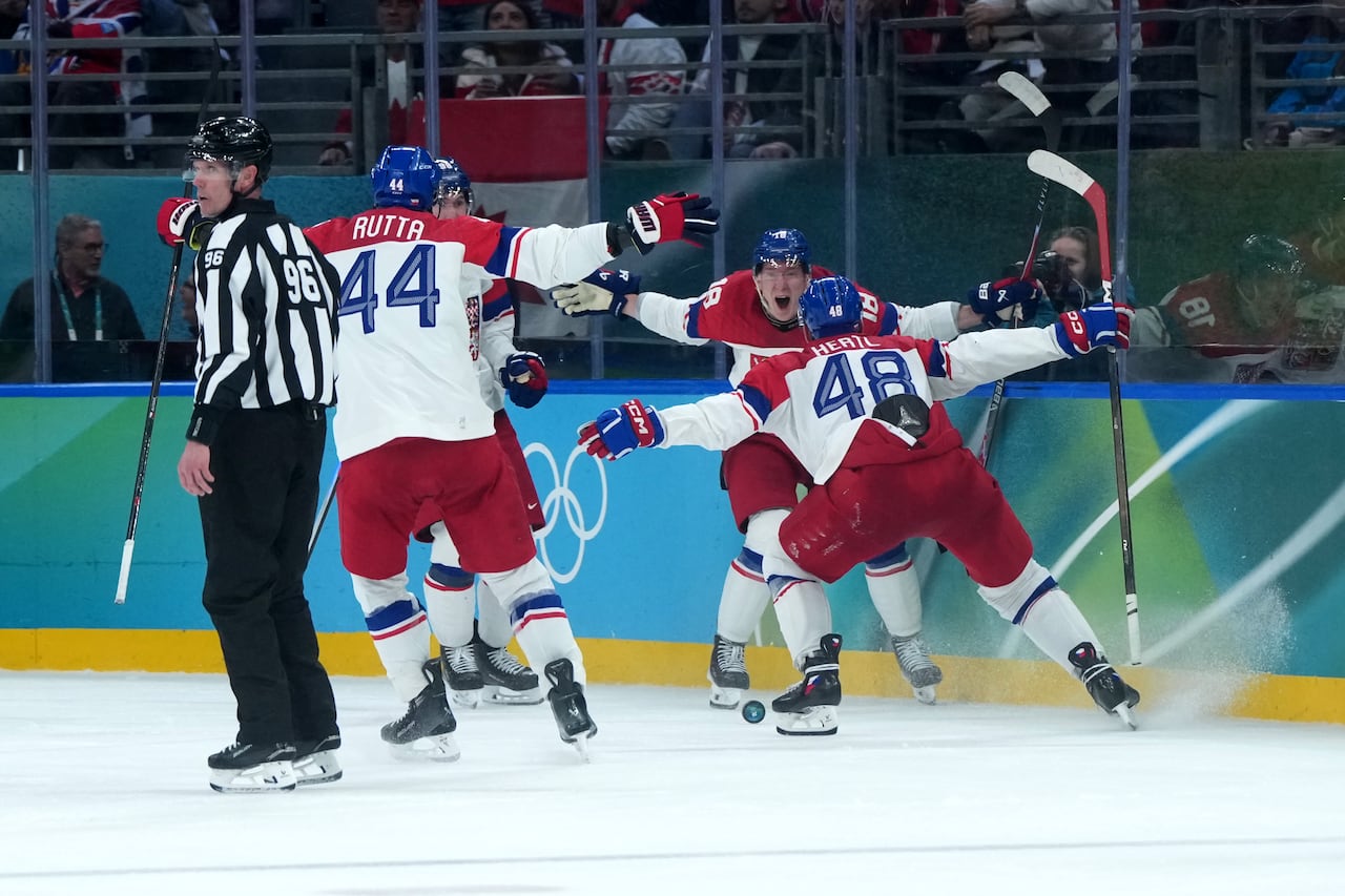 Hockey players celebrate on the ice.