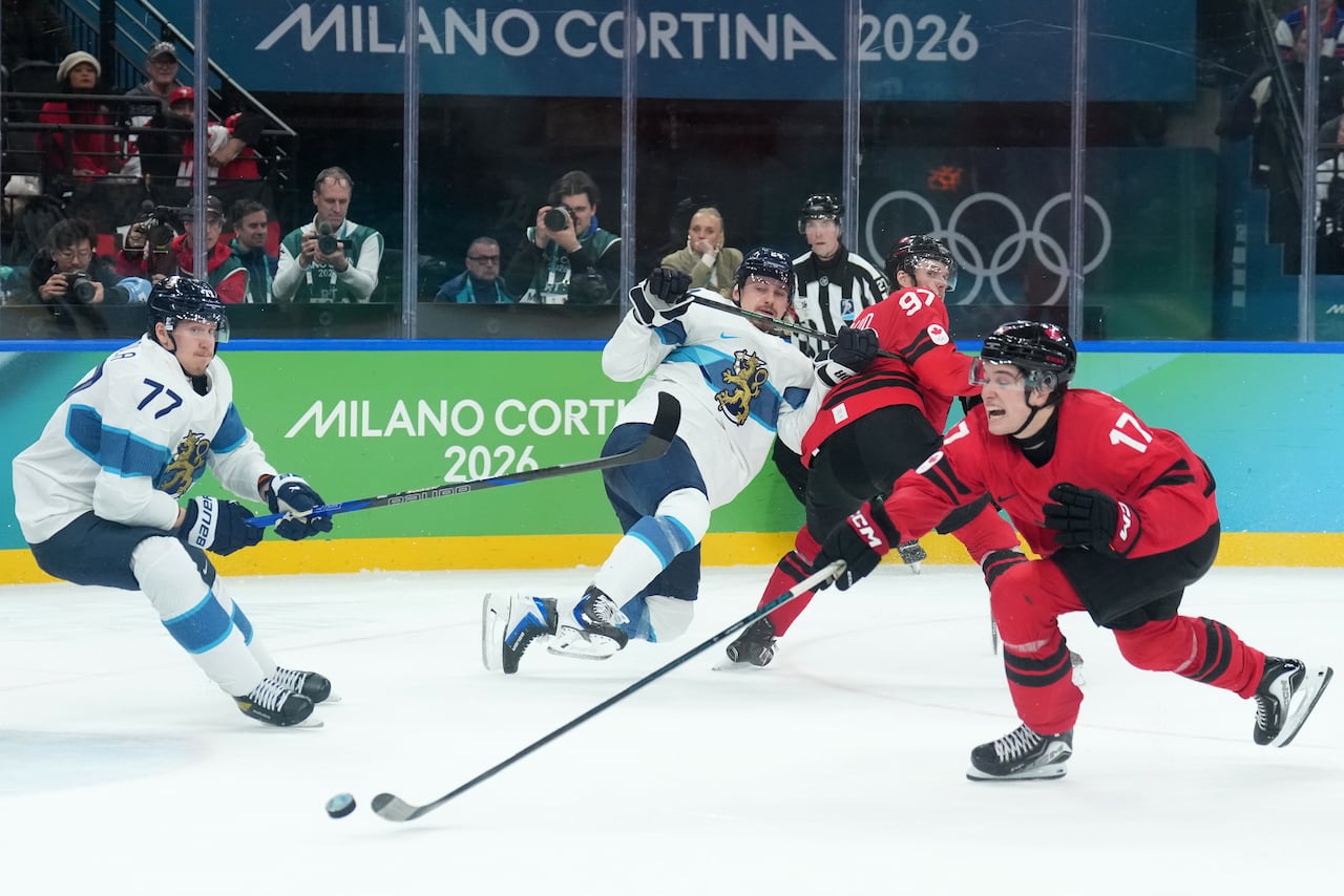 A hockey player reaches for a puck during a game.