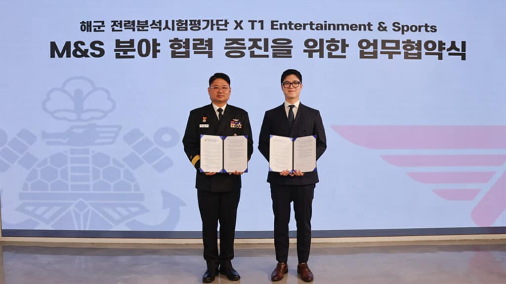 Image of T1 and South Korean Navy representative standing together while holding a contract