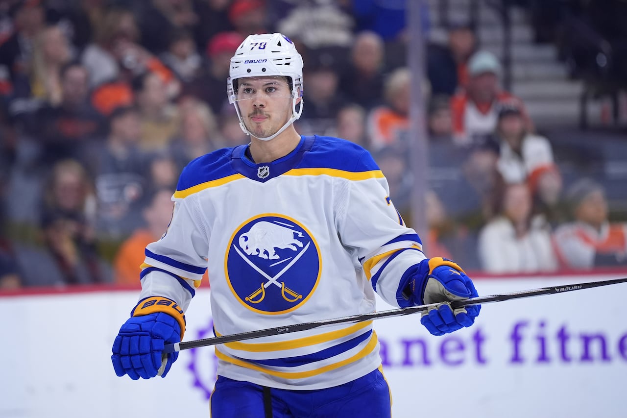 A hockey player in a white, yellow and blue jersey