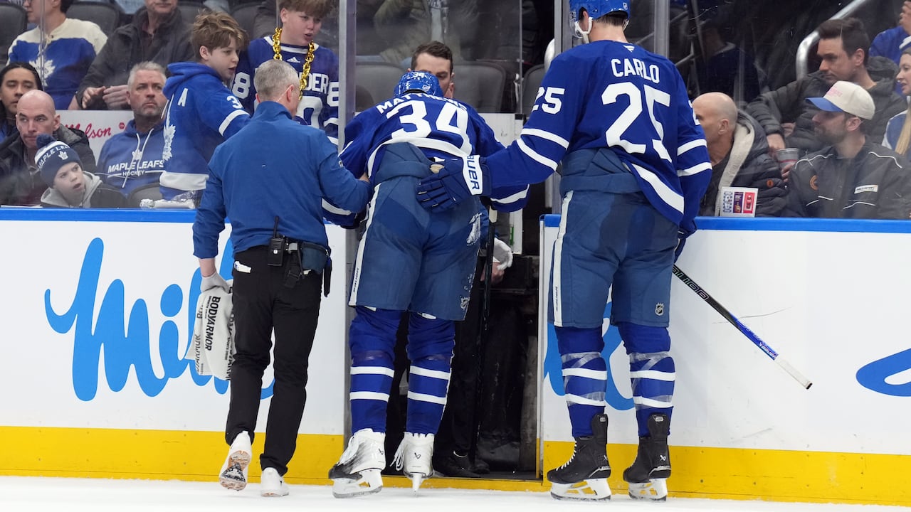 An injured men's hockey player is taken off the ice.