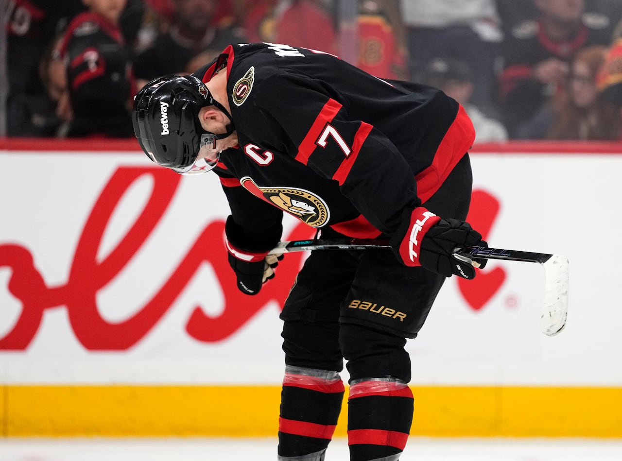 A hockey player looks down on the ice
