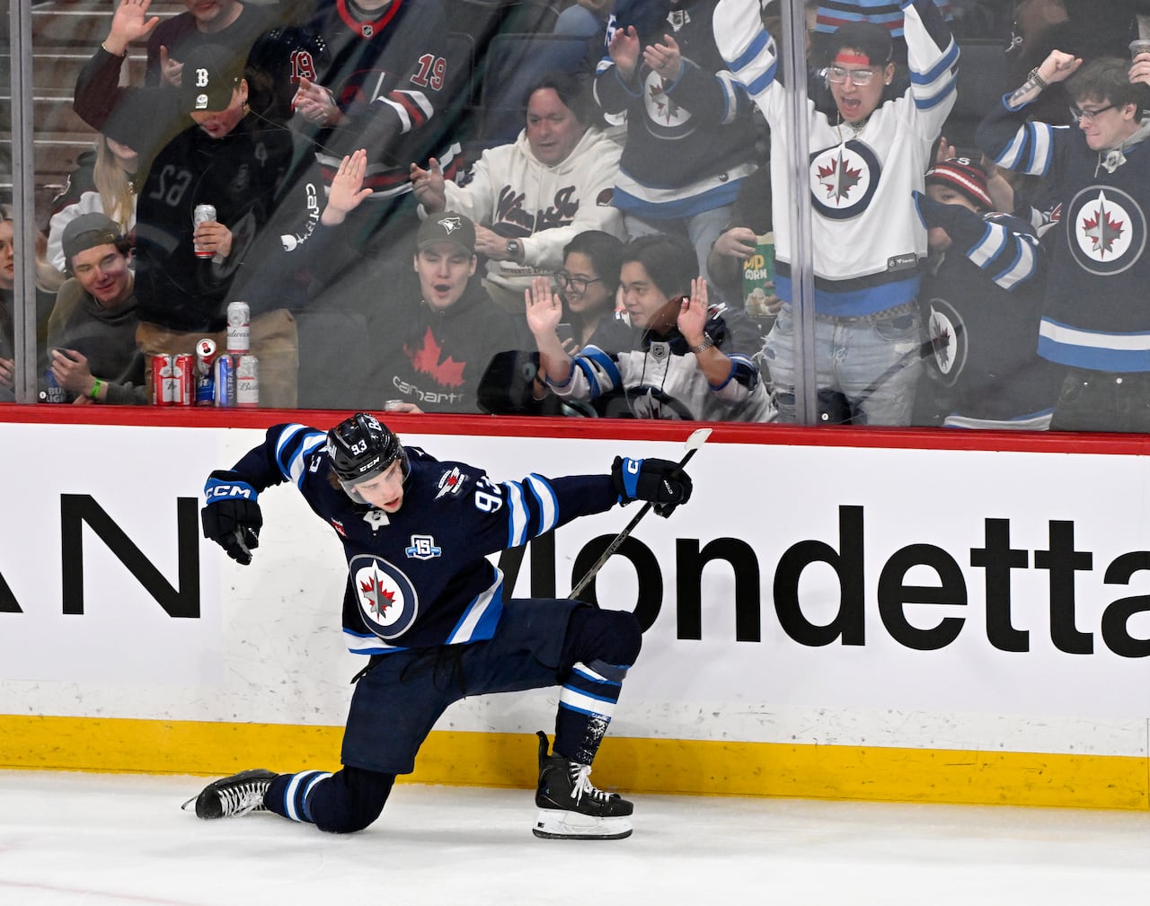A hockey player slides on one knee as he celebrates a goal