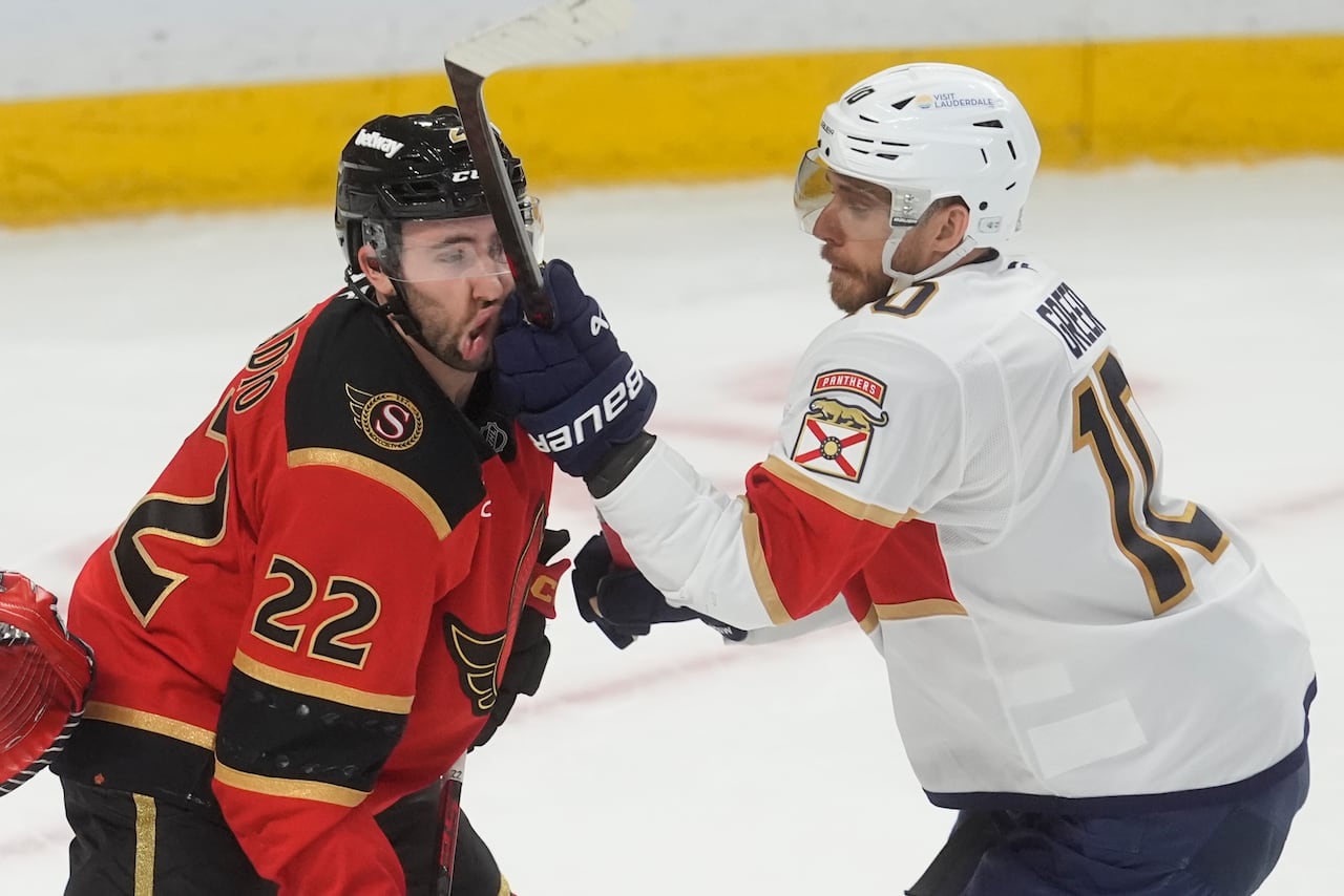 A hockey player hits another in the face with his glove.