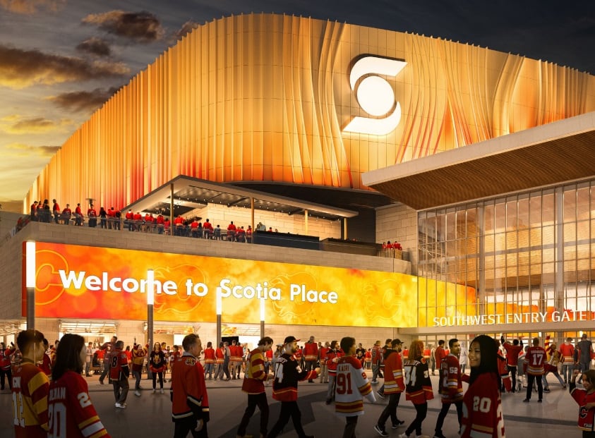 An exterior view of an arena lit in red and orange with the words 