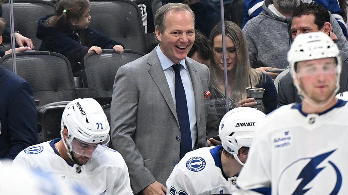 Tampa Bay Lightning's head coach, Jon Cooper, sharing a jovial instant on the team bench during a timeout in an NHL regular season match on March 7 against the Toronto Maple Leafs at their home arena.