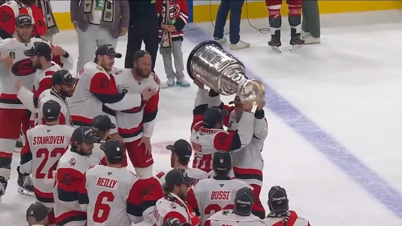 A player hands off a trophy to a teammate.