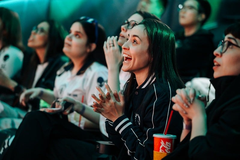 A group of female esports enthusiasts watching a live tournament match