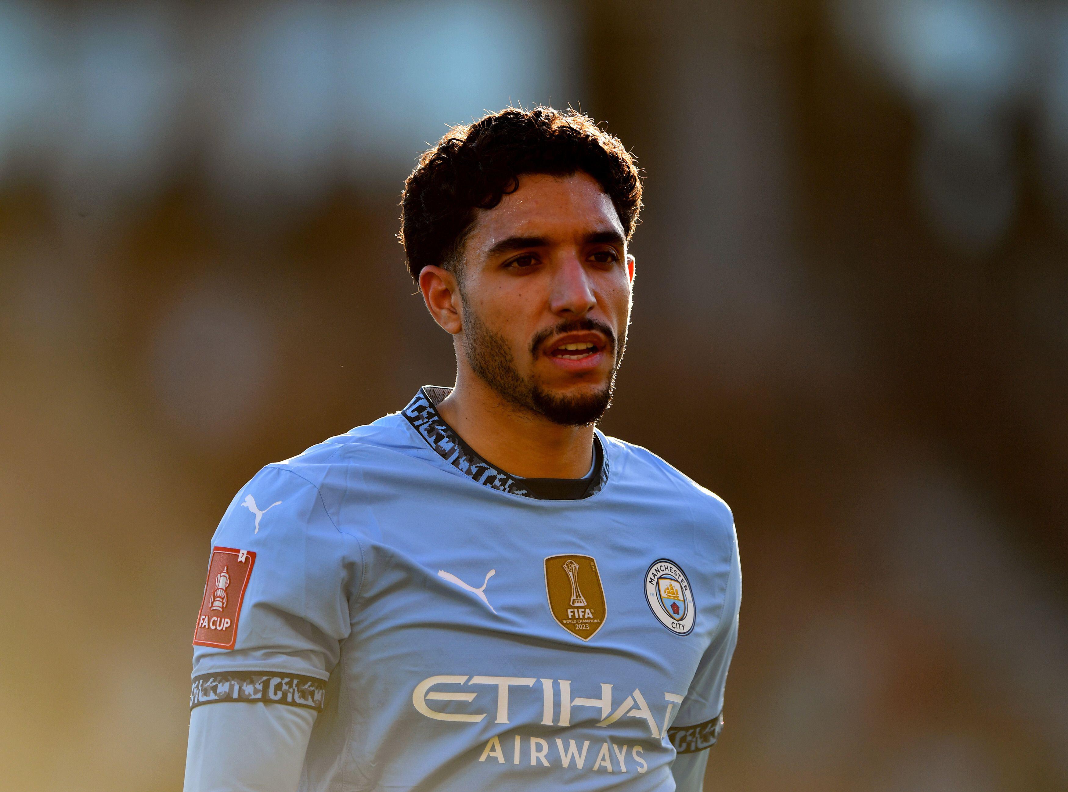 Manchester City's Omar Marmoush observes the action during an FA Cup quarter-final clash against AFC Bournemouth, captured in a mid-shot, walking profile.