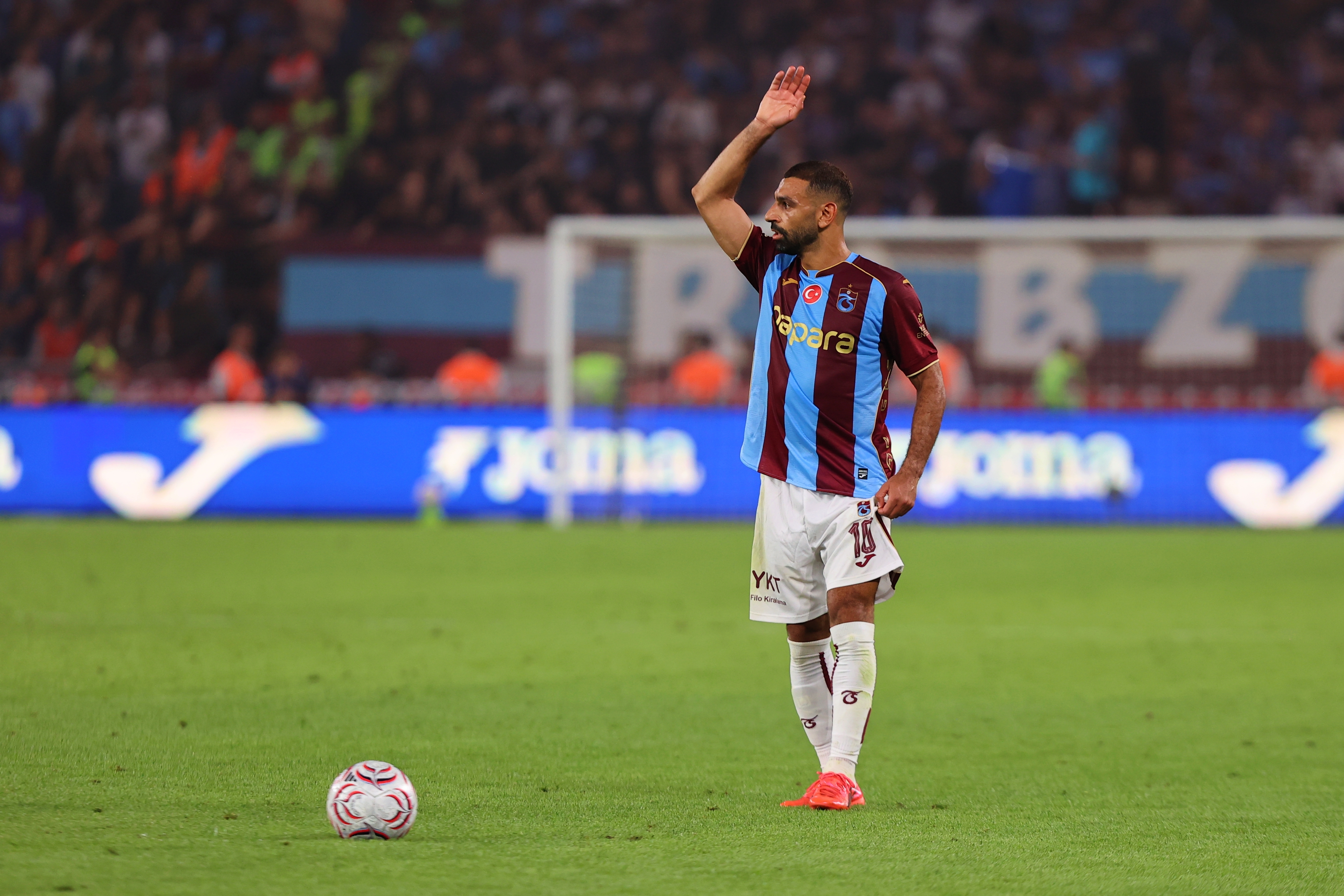 Mohamed Salah stood next to a still ball, arm raised, during the match between Trabzonspor and Ferencvaros. (Photo by Hasan Tascan/Anadolu via Getty Images)