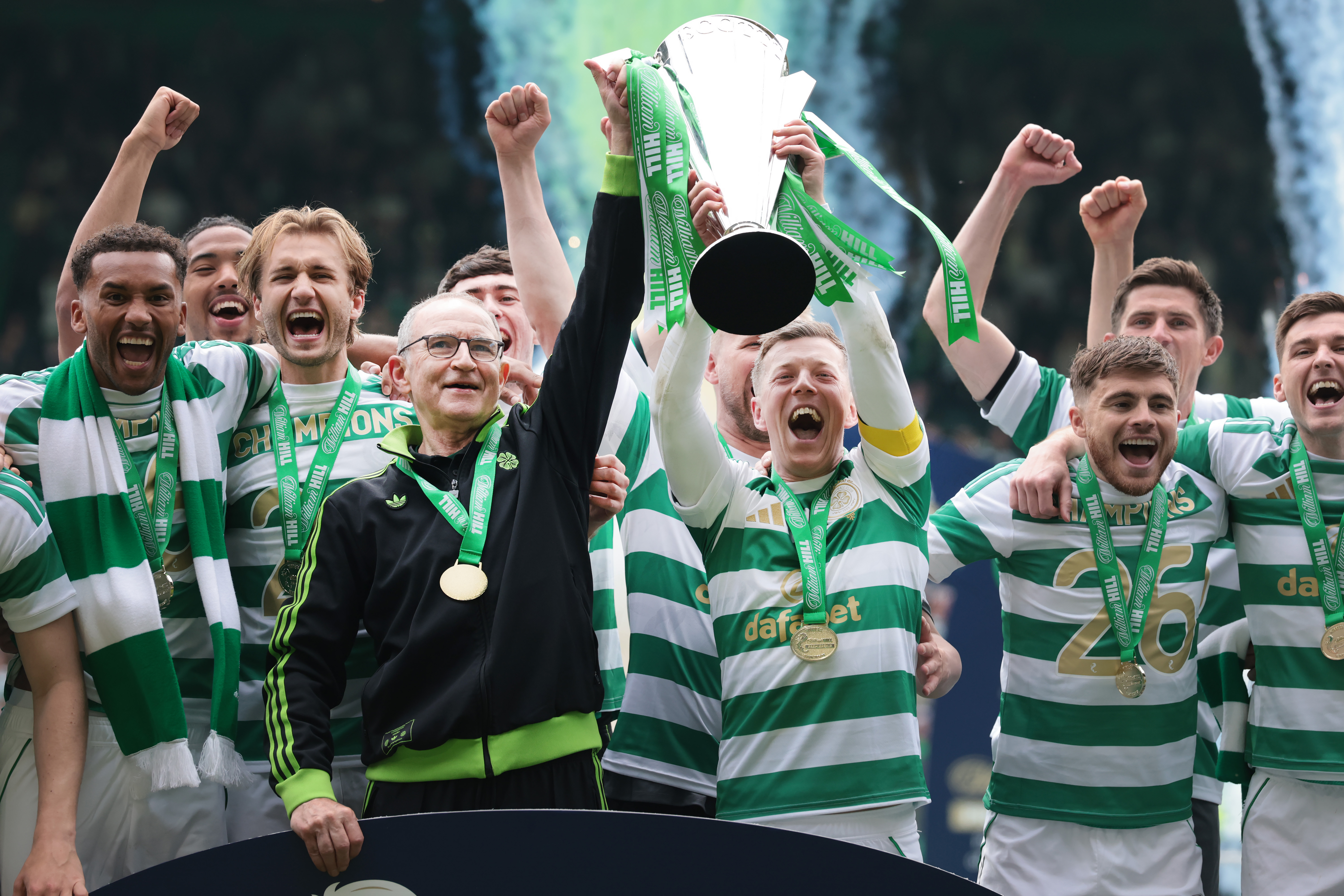The Celtic squad alongside their coach celebrating with the Scottish Premiership silverware.