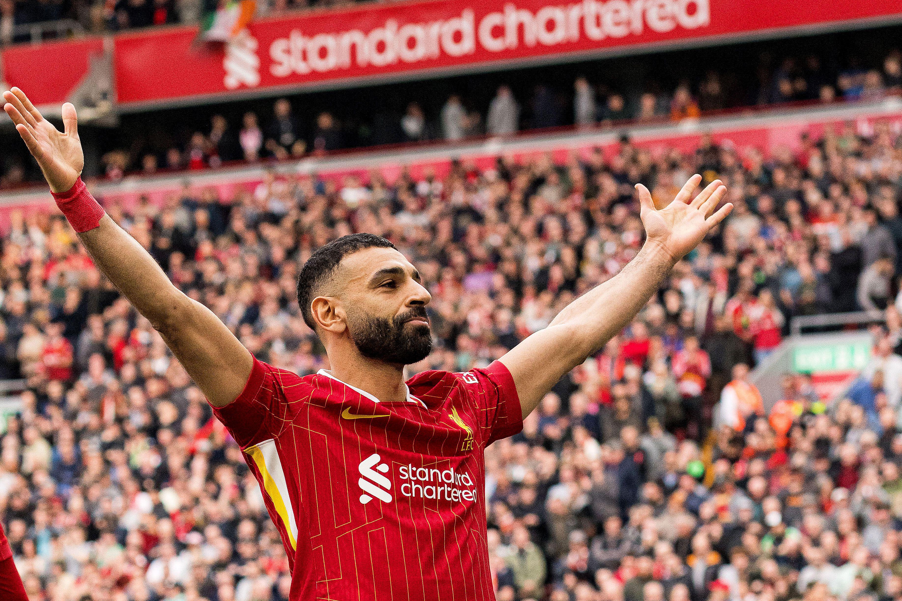 Mohamed Salah celebrates, arms raised, after scoring a penalty.