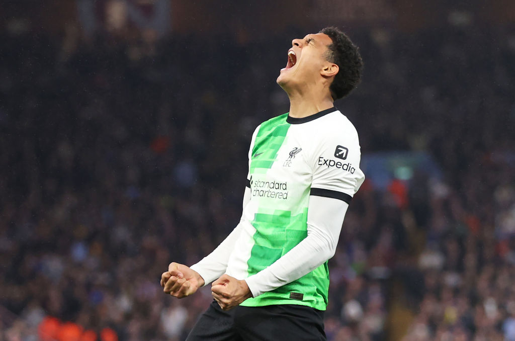 Jarell Quansah of Liverpool celebrates scoring, arms flexed, shouting at the sky.