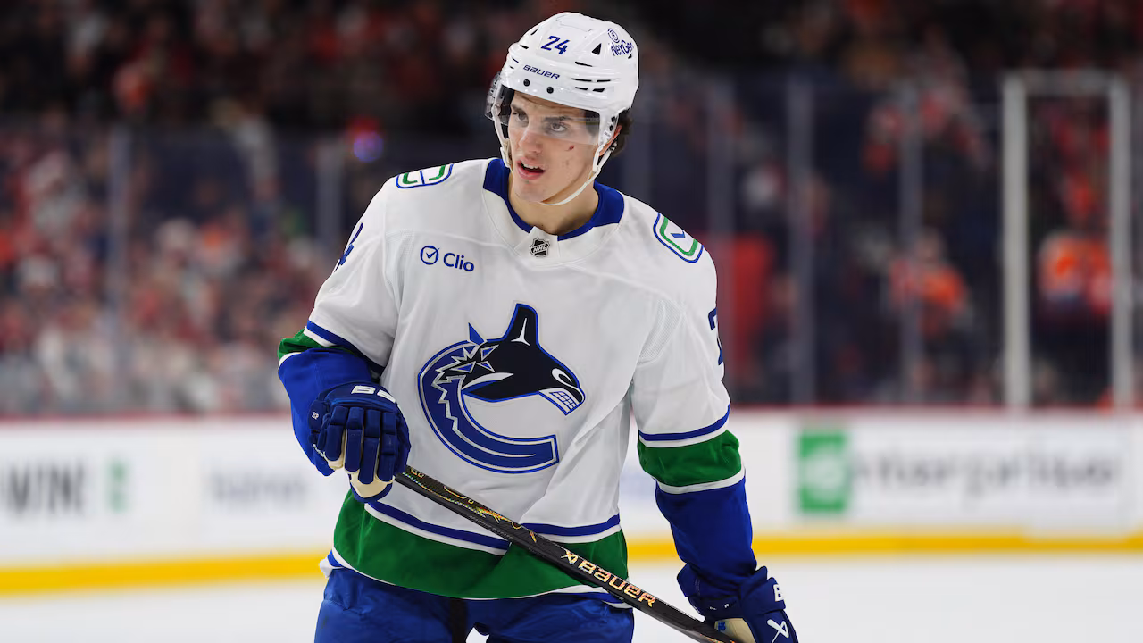 A hockey player wearing white is seen on the ice.