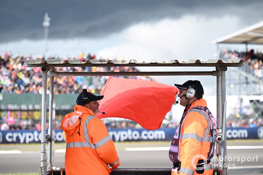 Track marshals displaying the red flag