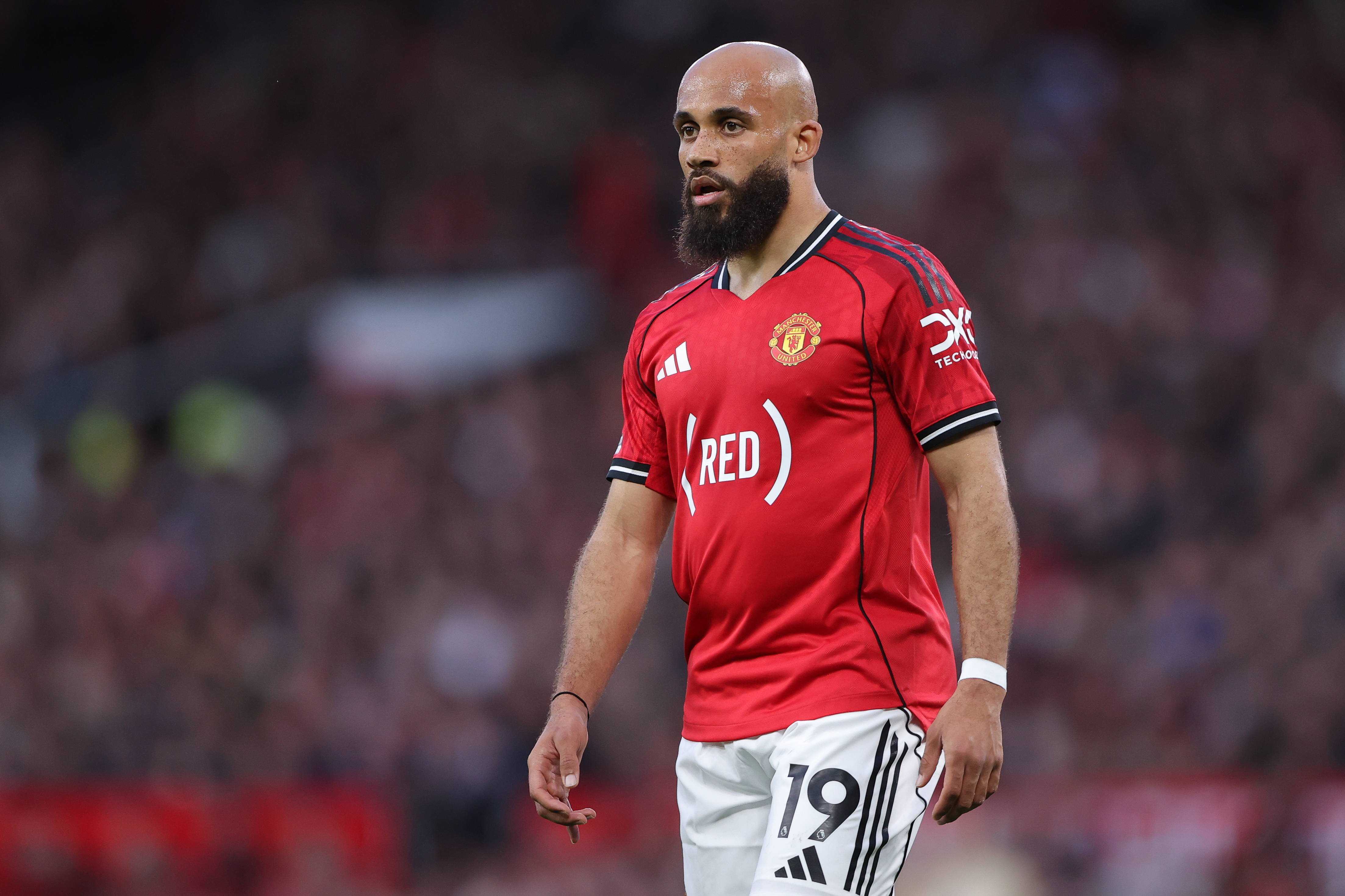 Manchester United forward Bryan Mbeumo walking on the pitch.