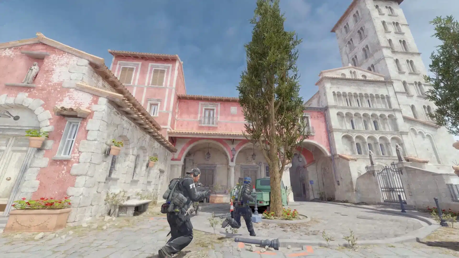Counter-Strike 2 gameplay showing characters in tactical gear in a Mediterranean-style town square.