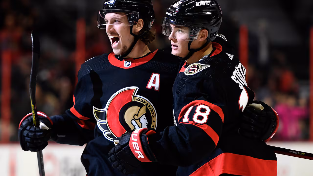 Ottawa Senators forward Tim Stutzle (18) rejoices over his goal with blue-liner Thomas Chabot (72) during the second period of an NHL game versus the Colorado Avalanche in Ottawa, Saturday, Dec. 4, 2021. THE CANADIAN PRESS/Justin Tang Two ice hockey players embracing on the rink.